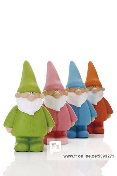 Four colourful garden gnomes in a row