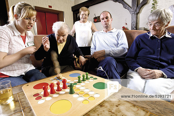 Im Altenheim  Pflegeheim  Spielenachmittag mit Pflegerin und Bewohnern