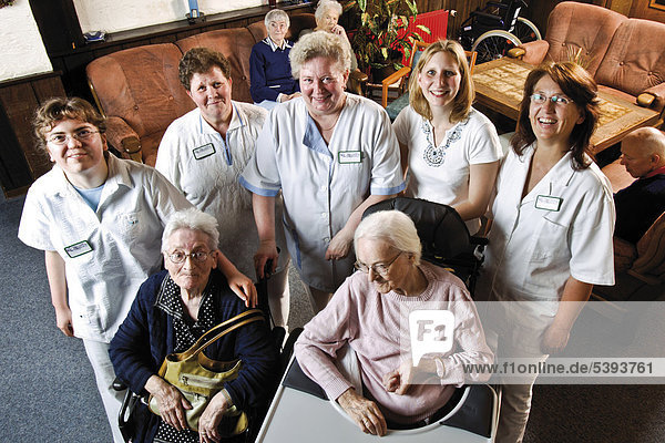 Residents and caretakers  nursing staff in the common room of a nursing home