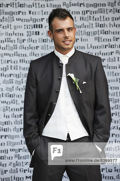Wedding  groom standing in front of a wall with letters