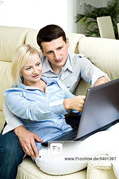 Junges Paar mit Laptop zu Hause