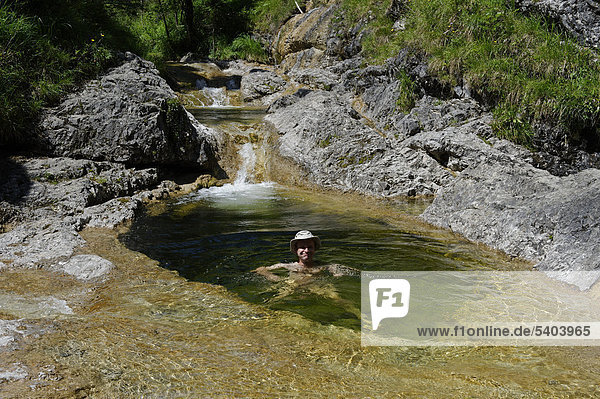 Man bathing in a water hole  pool on the Schronbach creek  Schronbachtal valley  Isarwinkel  near Lenggries  Upper Bavaria  Bavaria  Germany  Europe