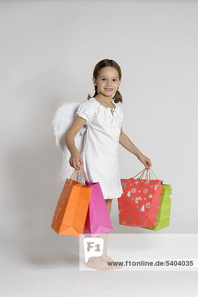 Girl dressed up as a Christmas angel with gifts  Christmas