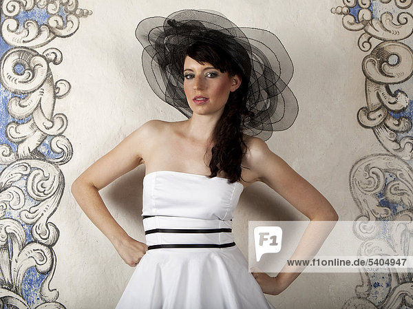 Junge Frau mit Hut und weißem Kleid