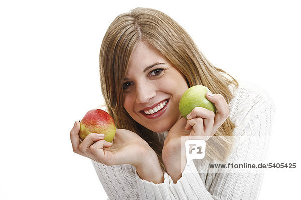 Junge Frau in weißem Pullover mit Äpfeln in den Händen