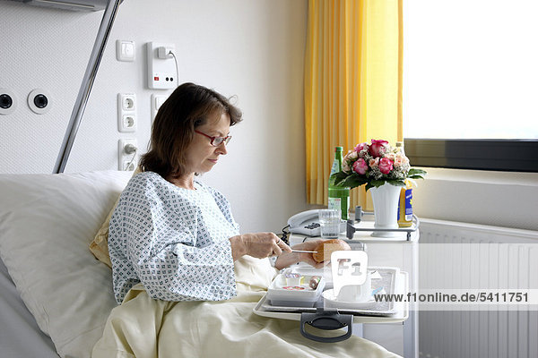 Patientin im Krankenbett nimmt eine Mahlzeit zu sich  Krankenhaus
