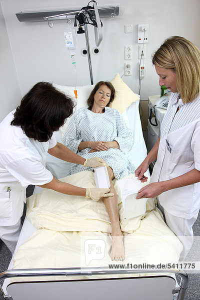 Krankenschwestern wechseln den Verband einer Patientin im Krankenbett  Krankenhaus