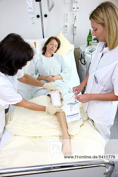 Krankenschwestern wechseln den Verband einer Patientin im Krankenbett  Krankenhaus
