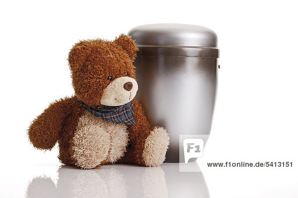 Silver-grey urn and a teddy bear