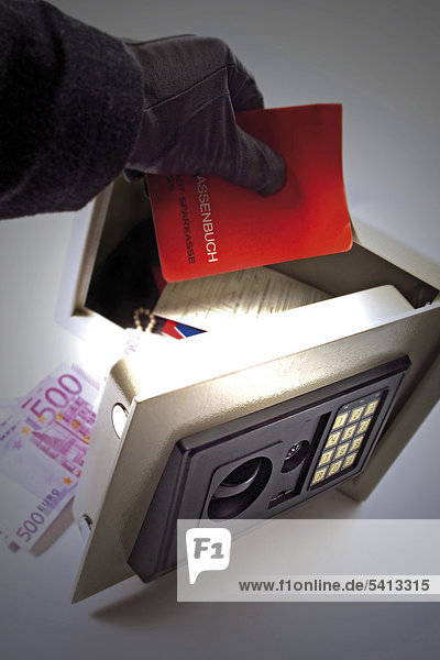 Hand taking a bank book out of a safe