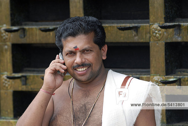 Telefonierender Hindu-Priester  Tempel von Ettumanur  Kerala  Südindien  Indien  Asien