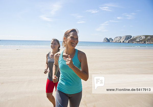 Zwei Frauen joggen am Strand