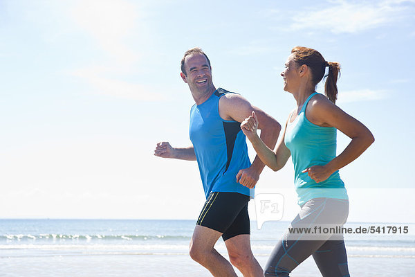 Mann und Frau joggen am Strand