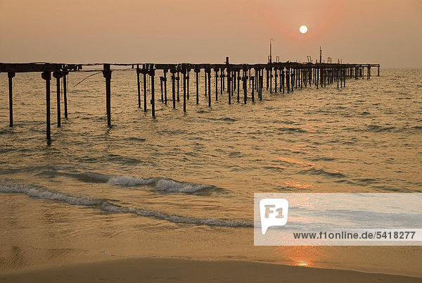 Sonnenuntergang über dem Arabischen Meer hinter der Ruine des Piers von Alleppey  Kerala  Indien  Asien