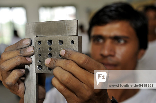 Berufsausbildung zum Schlosser  Berufsschüler kontrolliert seine Arbeit an einem Stahlbarren auf Genauigkeit  Youhanabad  Lahore  Punjab  Pakistan  Asien