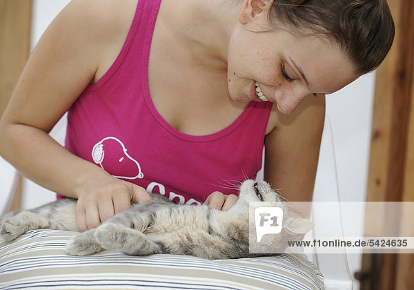 Tierliebe  junge Frau streichelt getigerte Katze  Dolcedo  Riviera dei Fiori  Ligurien  Italien  Europa