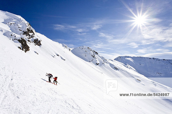 Ski tourers climbing Mt Hoertlahner or Punta Lavina above Durnholz  Sarntal valley or Sarentino  Mt Cima di San Giacomo in the back  South Tyrol  Italy  Europe