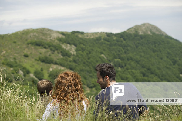 Junge Familie mit Blick auf die Berge  Rückansicht