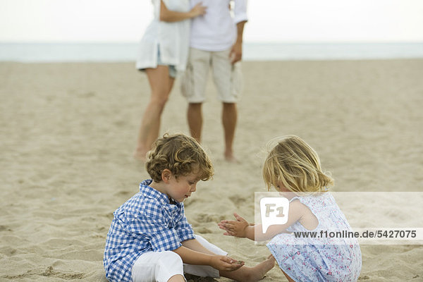 Kinder spielen im Sand am Strand