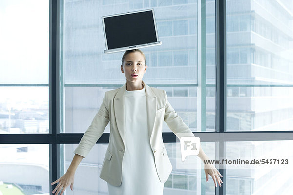 Geschäftsfrau mit Laptop auf dem Kopf