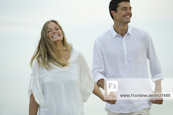 Couple walking hand in hand outdoors