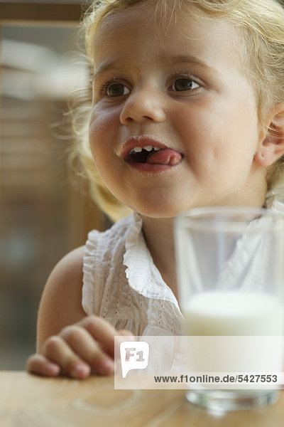 Kleines Mädchen genießt ein Glas Milch