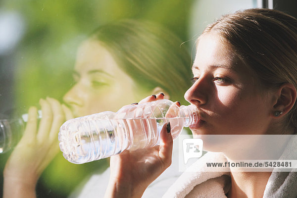 Young Woman Drinking gekämpft Wasser während des physischen Trainings in ein Fitness-Studio