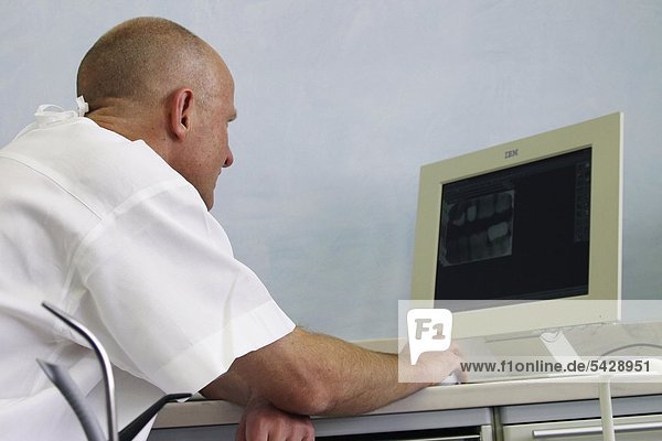 Physican considers radiography on computer monitor