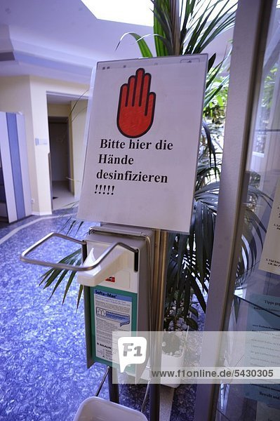 Schild mit der Aufschrift '' Hände desinfizieren '' im Eingangsbereich des Dialysezentrums'