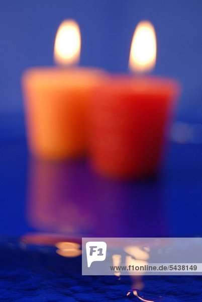 Zwei verschwommen abgebildete brennende Kerzen - Symbol für Tod und Trauer oder Zärtlichkeit -