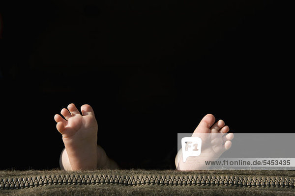 Die Fußsohlen eines Babys liegen auf einem Kissen.