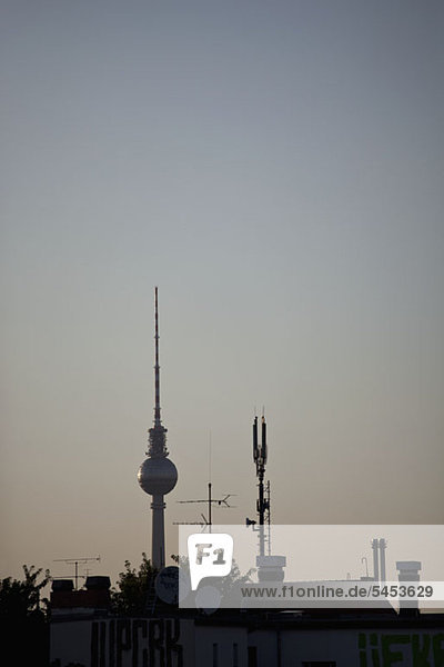 Der Fernsehturm am Alexanderplatz hinter einem Dach mit Antennen