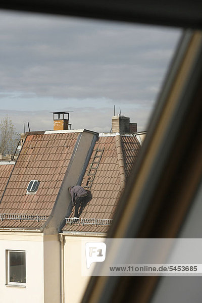 Ein Mann  der ein Dach repariert.
