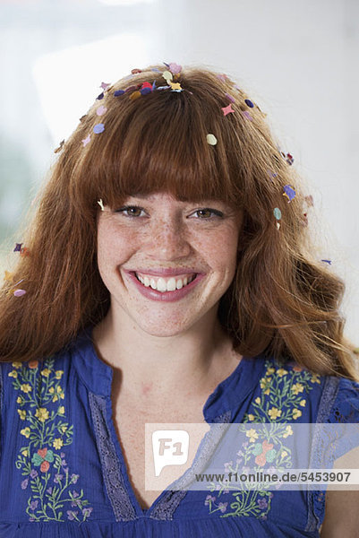 Eine glückliche junge Frau mit Konfetti im Haar