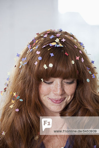 Eine junge Frau mit Konfetti im Haar.