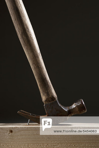 Hammer zum Entfernen eines Nagels von einem Holzbalken