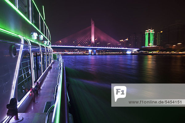 Yacht auf dem Pearl River in Hongkong und beleuchtete Haiyin Bridge im Hintergrund