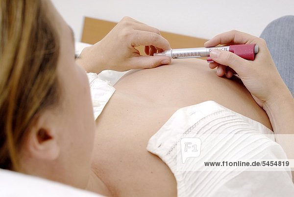 Schwangere Frau mit Insulinpen