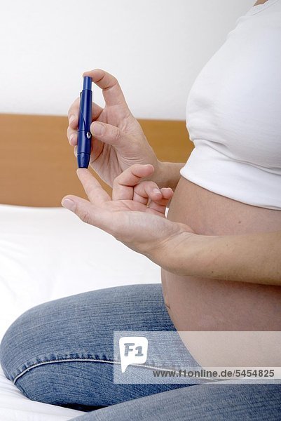 Schwangere Frau macht einen Diabetestest