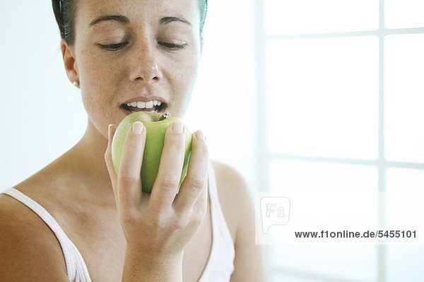 Frau beißt in einen Apfel