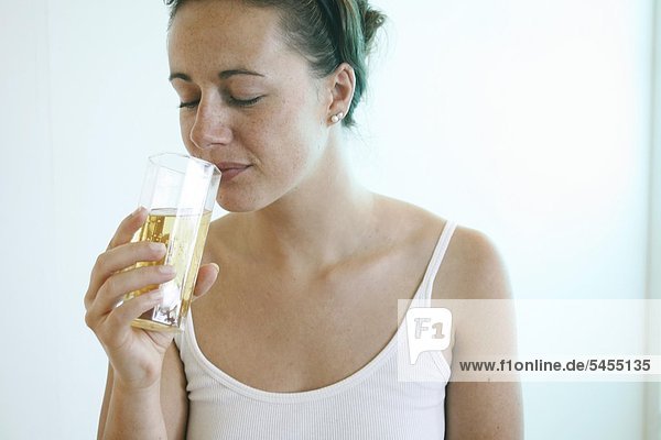 Junge Frau trinkt Saft.