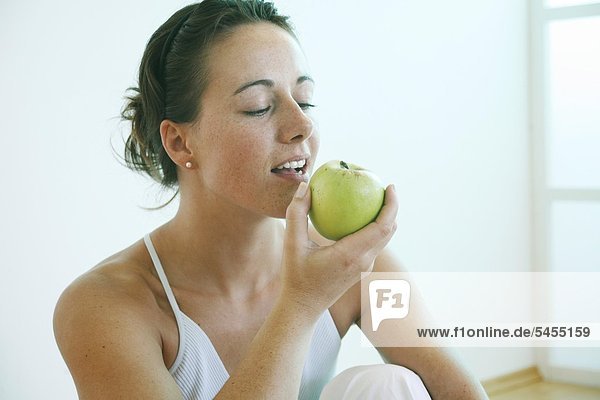 Junge Frau isst Apfel