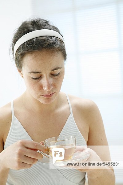 Serious woman holding glass of tea