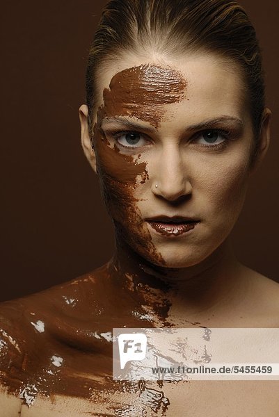 Gesicht einer jungen Frau mit Schokoladenmaske