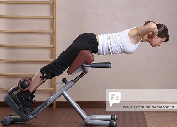 Junge Frau im Fitnessstudio beim Training der Rückenmuskulatur