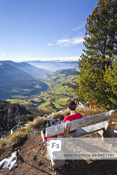 Wanderin macht Rast auf Bank am Herrensteig  hinten das Villnösstal  Südtirol  Italien  Europa