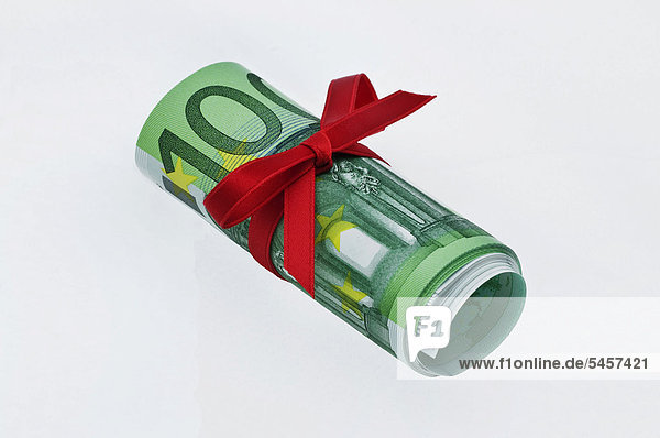 Rolle 100-Euro-Banknoten mit roter Schleife  Geldgeschenk