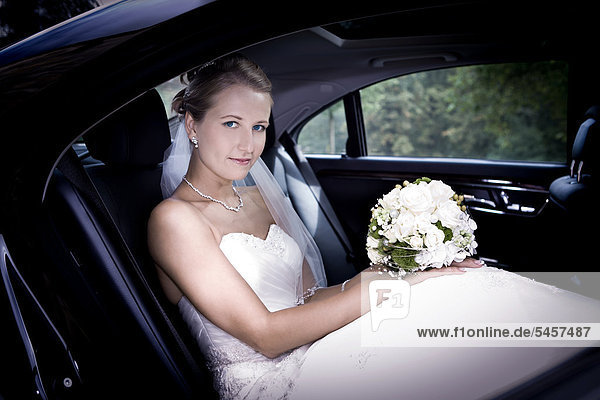 Junge Braut sitzt in einem Auto