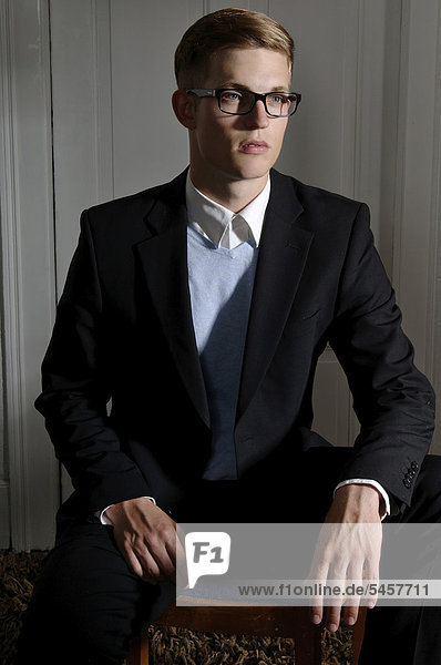 Junger Mann mit Brille und Anzug