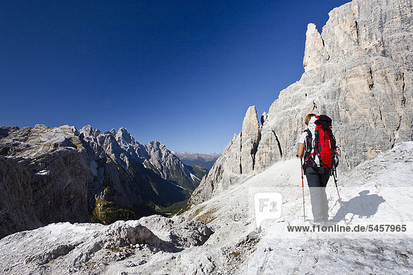 Wanderer im Alpinisteig am Einser  rechts der Elfer und Alpinisteig  hinten die Dreischusterspitze  Sexten  Hochpustertal  Dolomiten  Südtirol  Italien  Europa